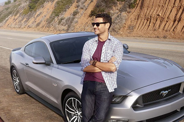 Young man standing alongside his Ford vehicle
